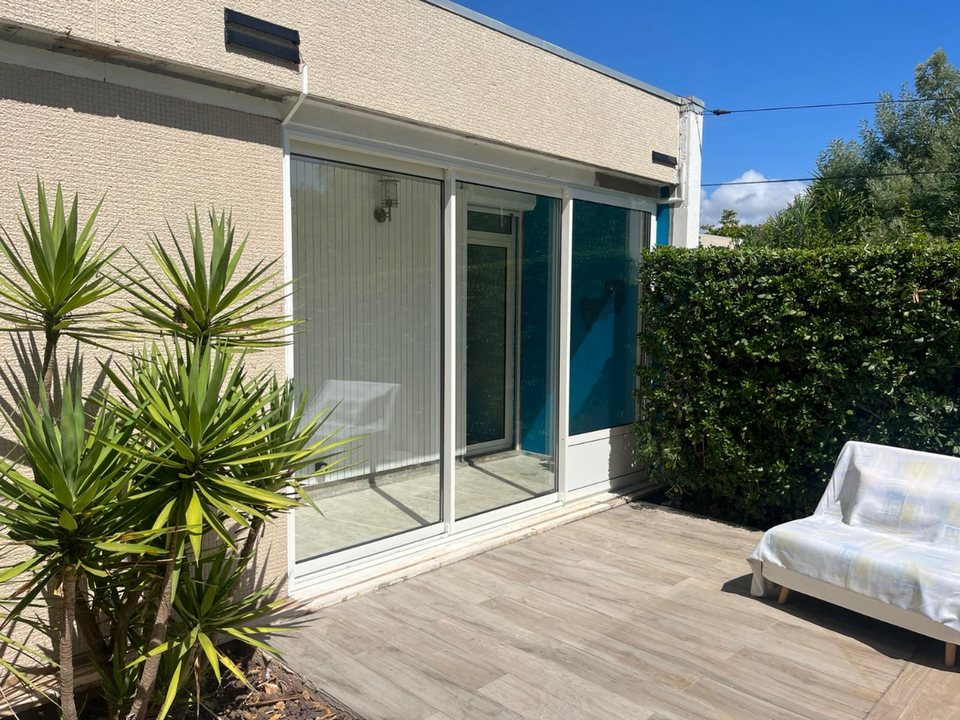 Grand coulissant aluminium blanc donnant sur une terrasse carrelée